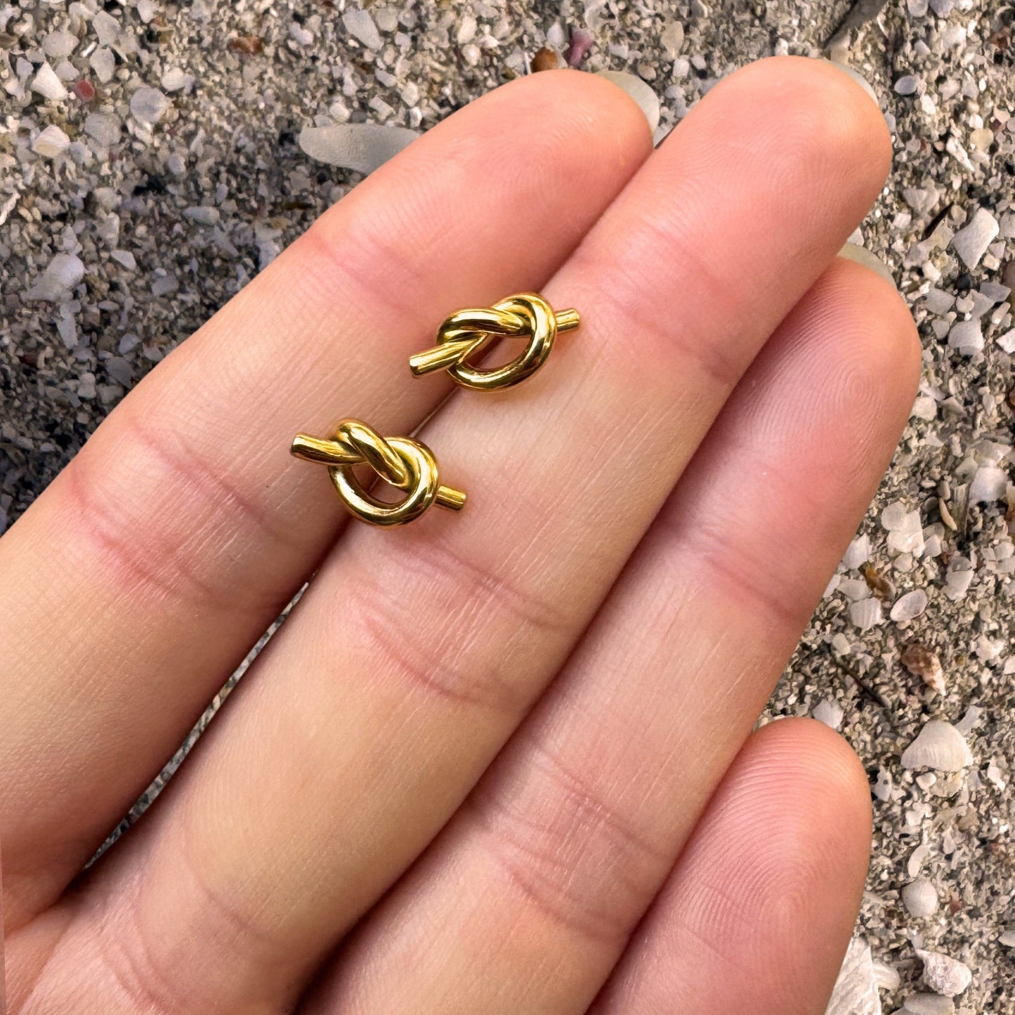 Gold Knot Stud Earrings in hand