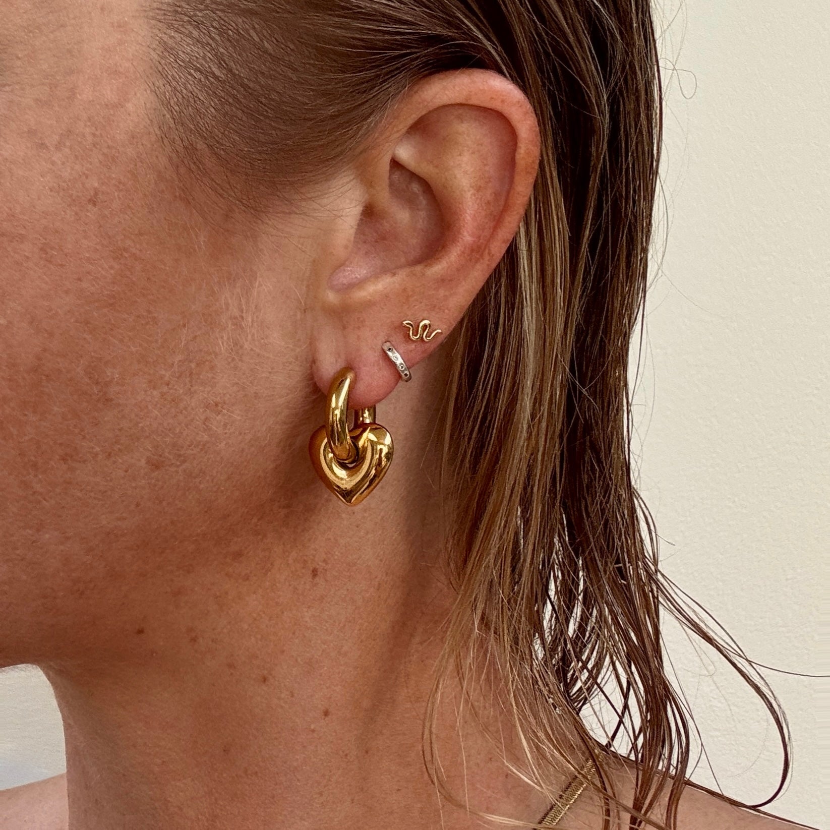 Gold plated chunky pierced heart huggie earrings from Jessica Rose jewellery