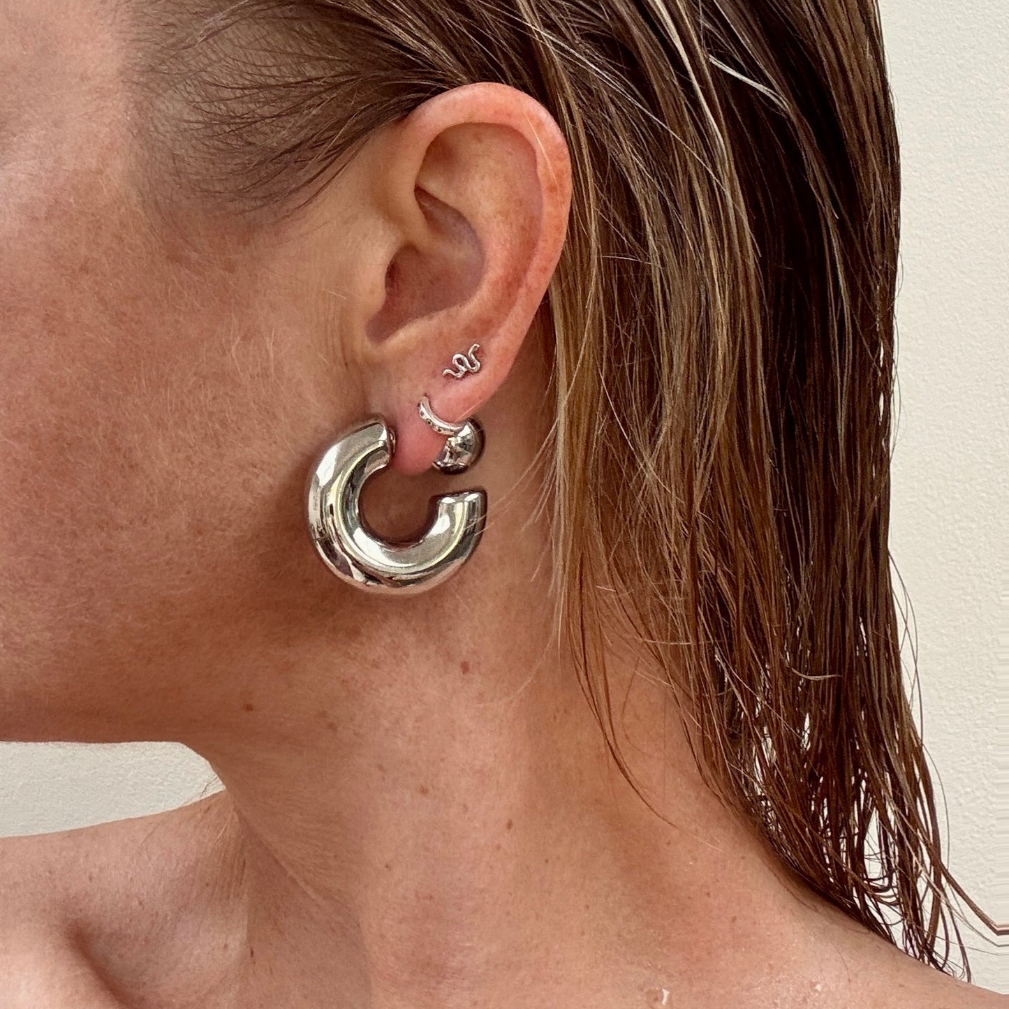 Silver chunky ball stud earrings from Jessica Rose jewellery worn on ear