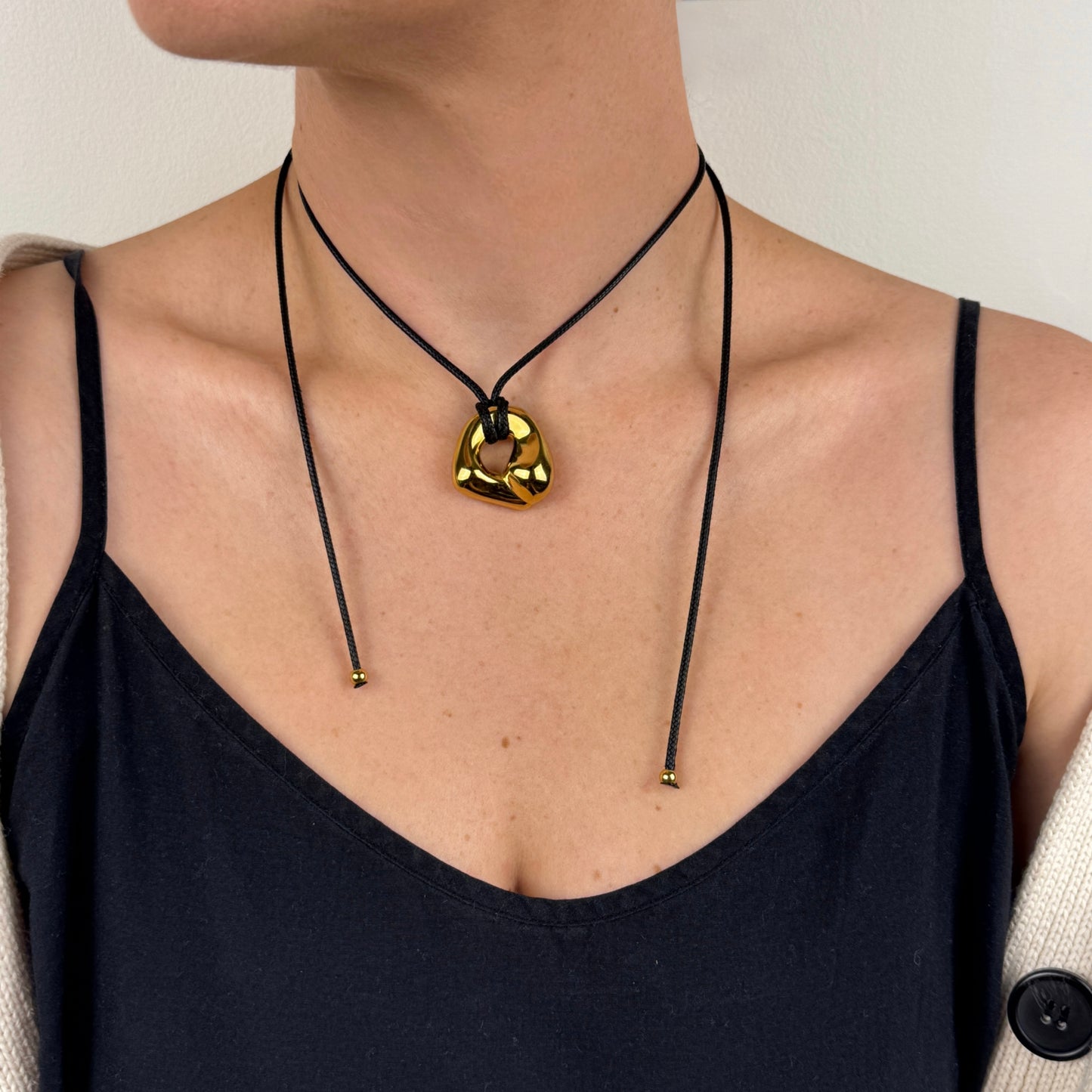 Adjustable gold plated molten irregular nugget pendant on black cord