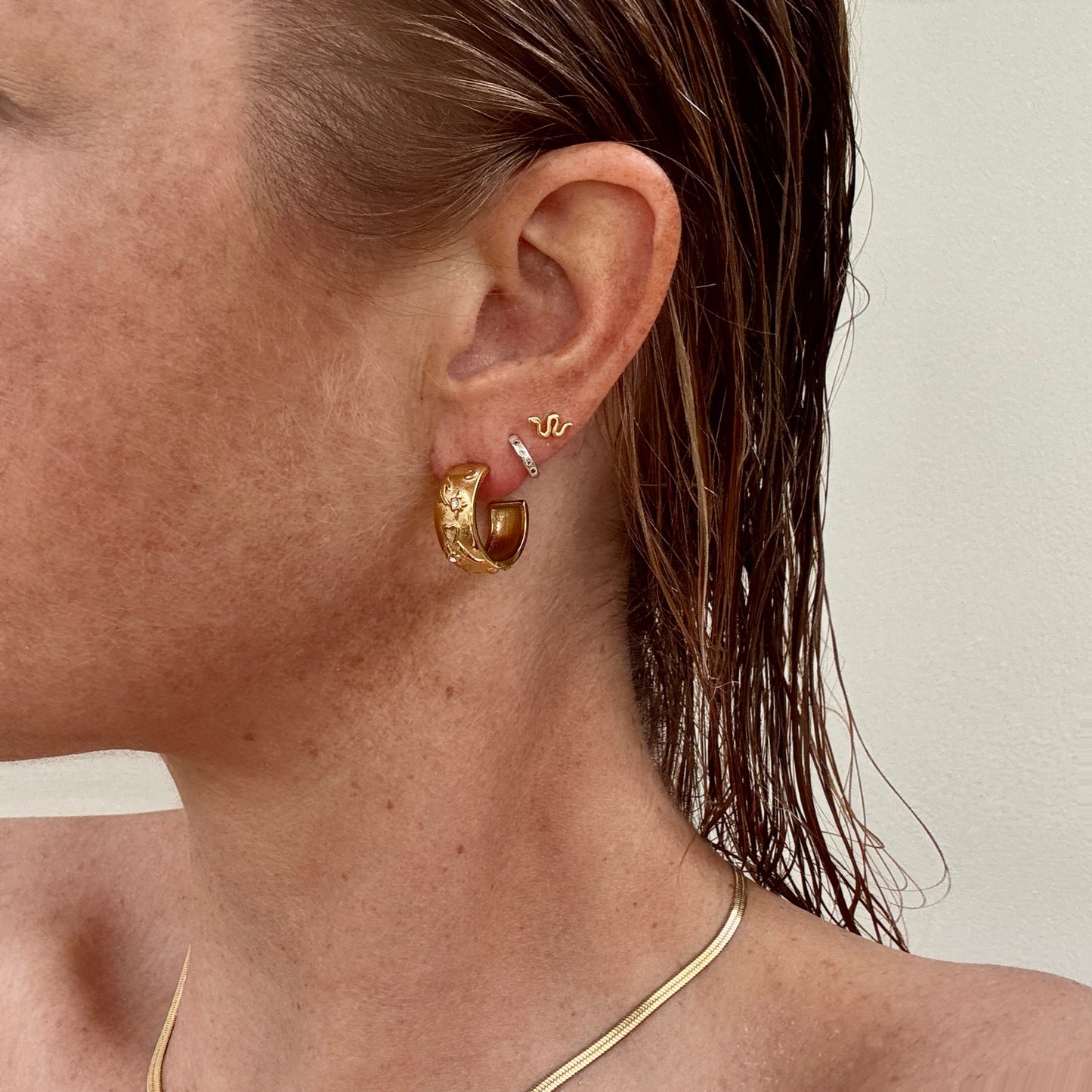 Gold plated tarot style earrings worn on ear by Jessica Rose jewellery